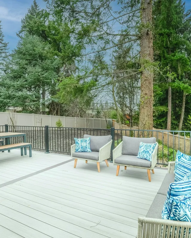 Finished backyard deck with patio furniture and railing